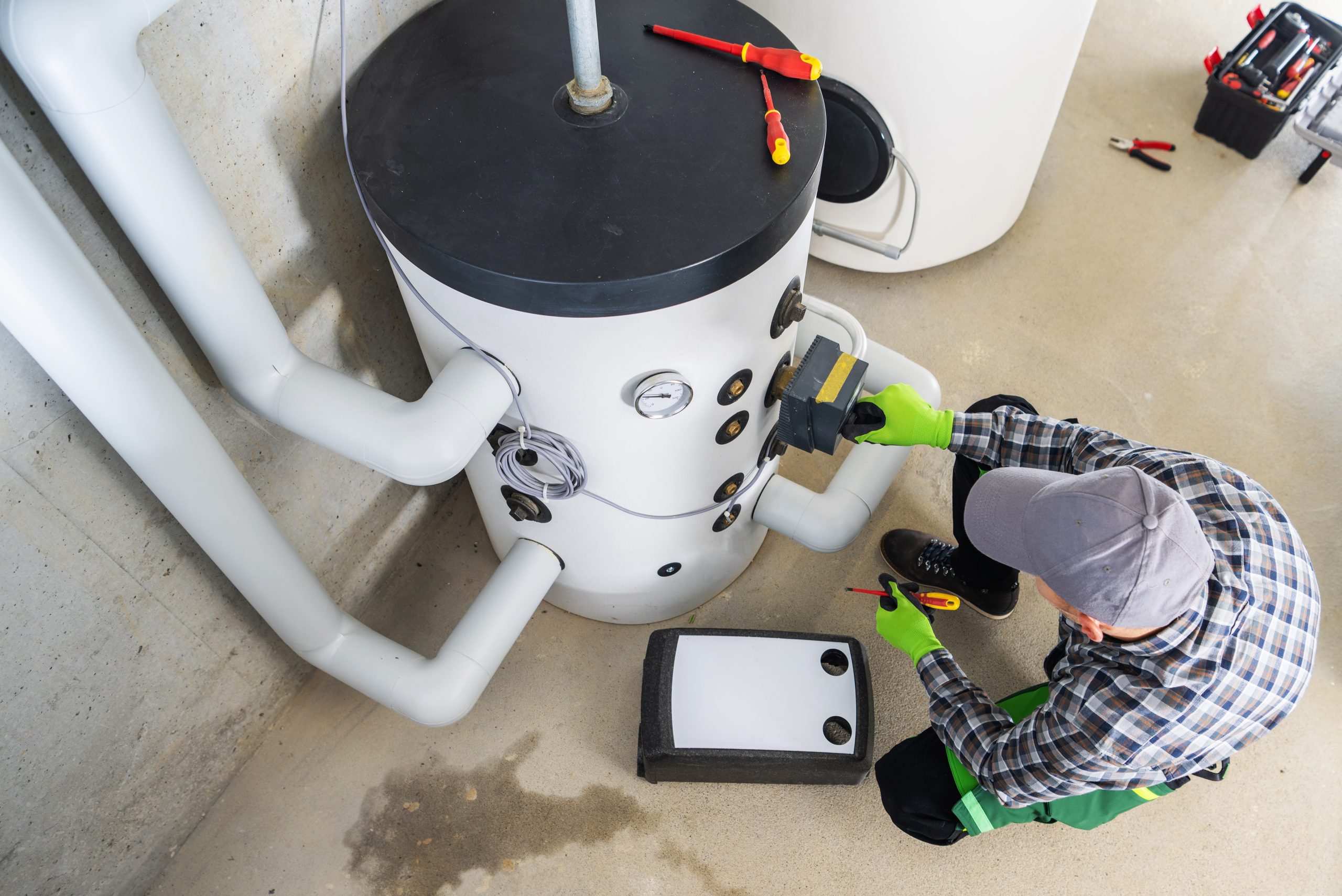 Water heater repair technician adjusting system components for proper performance.