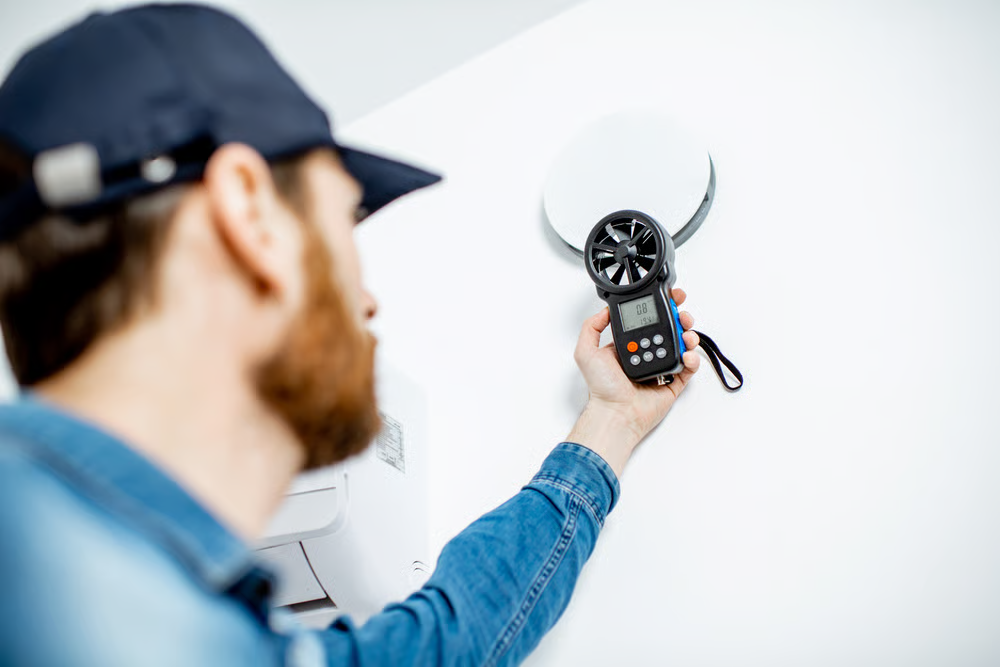 A technician checks airflow during cooling services.